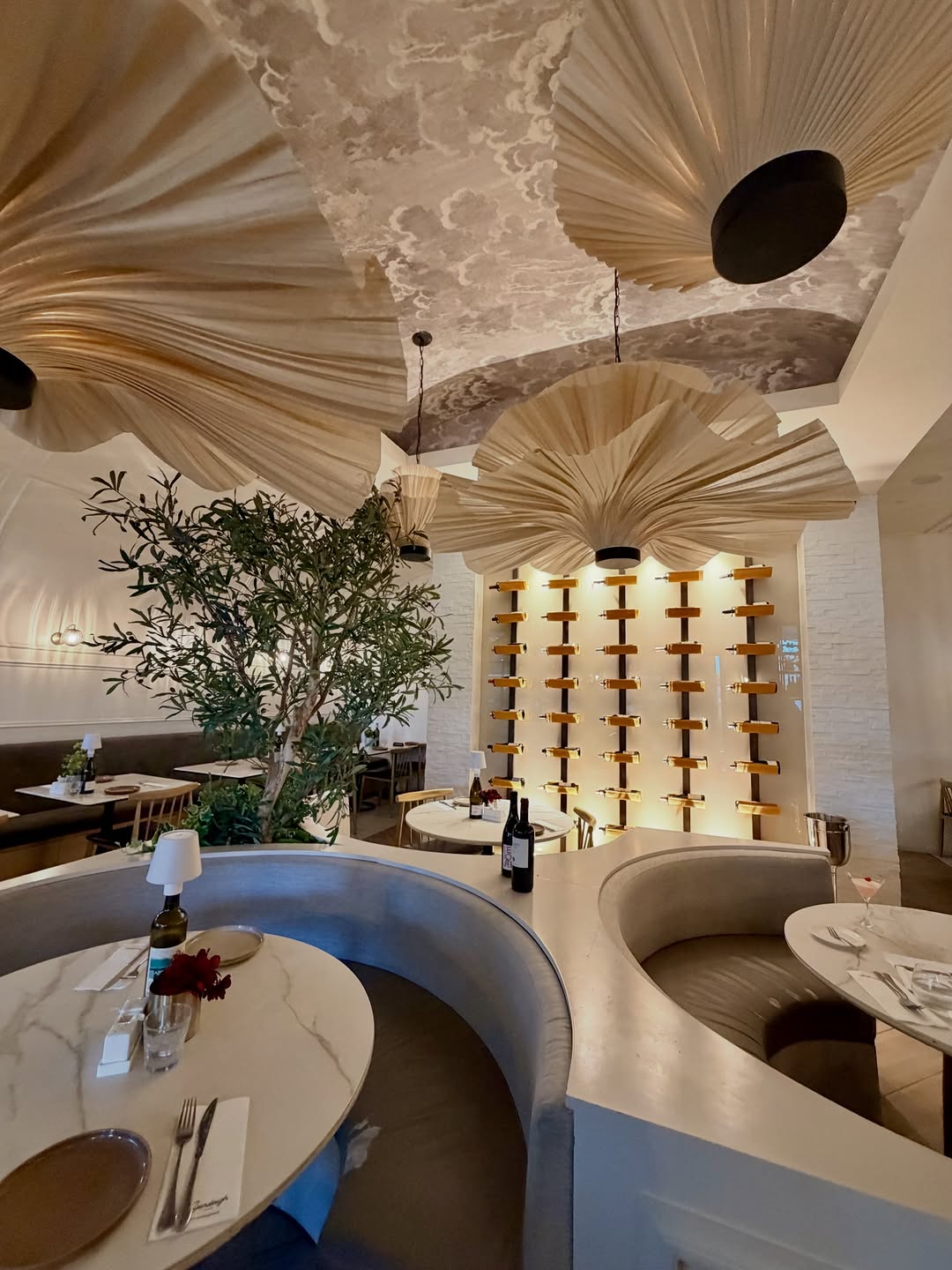 Sourdough Cafe Rockwell — dramatic pleated ceiling fans and wine bottle wall